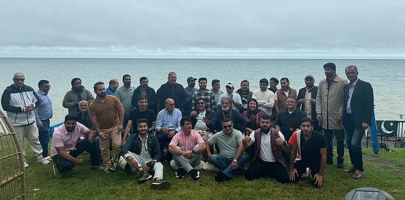 Around thirty-five people gathered in three rows beside Lake Ontario at the 2024 convention.
